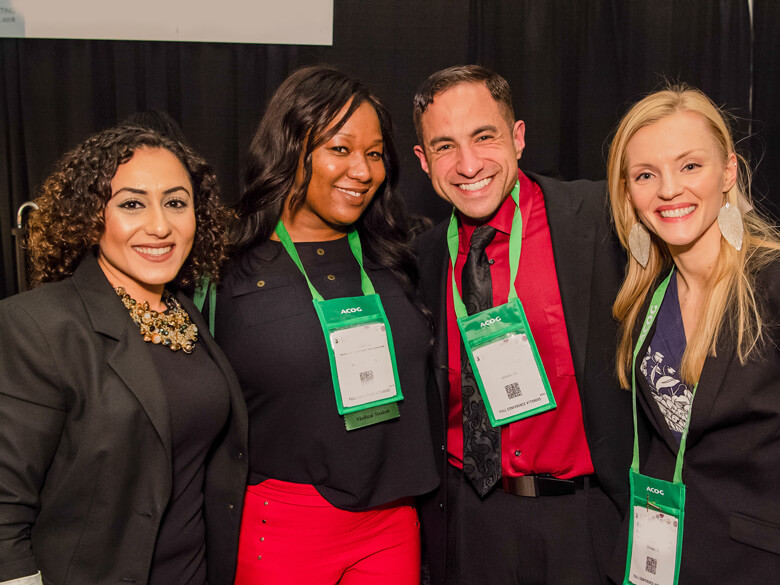 four members at a conference posing for the camera